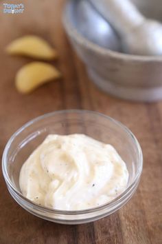 a bowl filled with mayonnaise sitting on top of a wooden table