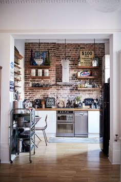 a kitchen with brick walls and wooden floors is pictured in this ad for the home depot