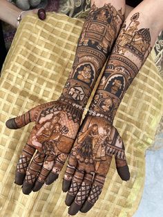 two hands that are decorated with henna and designs on them, one is holding the other