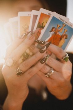 a woman holding four cards in her hands