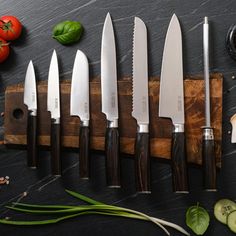 several knives are lined up on a cutting board