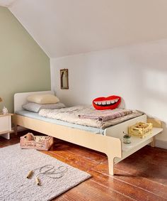 a bedroom with a bed, dresser and rug on the floor in front of it