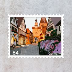 a postage stamp with an image of buildings and flowers on the street in front of them