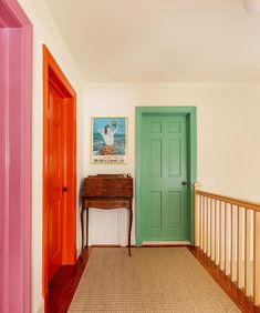 the hallway is painted bright and has two green doors on either side of the door