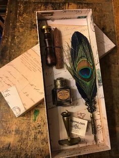 an open box with writing, ink and a feather quill