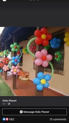 colorful balloons and streamers are on the side of a building in front of a lawn