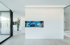 an aquarium is mounted to the wall in this white room