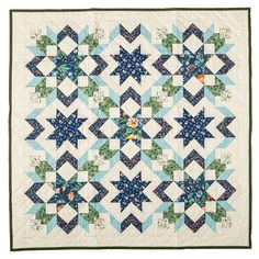 a blue and white quilt with stars on the front, along with green trimmings