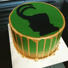 a green and gold cake with a silhouette of a woman's head on it