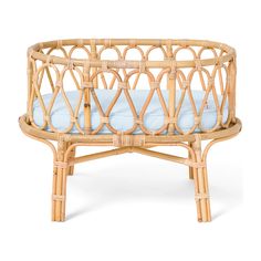 a wicker crib with blue cushions on it