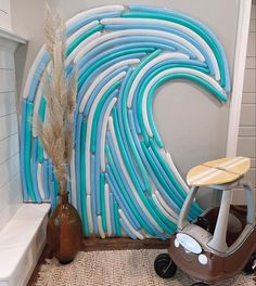 a surfboard shaped wall in the corner of a room next to a table and vase