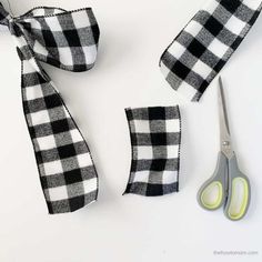 scissors and tape are laying next to each other on a white surface with black and white checkered ribbon