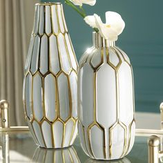 two white and gold vases with flowers in them