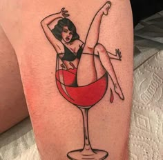 a woman is sitting in a wine glass tattoo