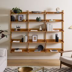 a living room filled with furniture and bookshelves next to a wall mounted shelf