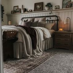 a bed sitting in a bedroom next to a dresser and window with pictures on the wall