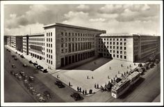 an old black and white photo of a building with cars parked in front of it