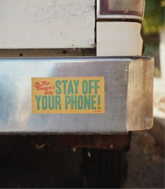 a sticker that says stay off your phone on the side of a car's bumper