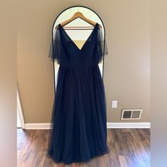 a dress hanging up on a hanger in front of a wall with a mirror