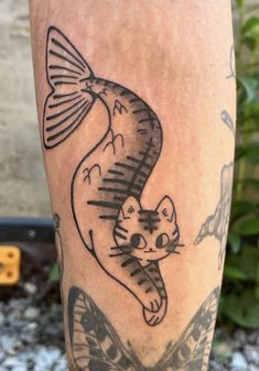 a close up of a person's leg with a tattoo on it and a cat