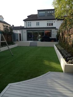 a large backyard with grass and wooden decking