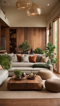 a living room filled with lots of furniture and plants on top of a wooden table