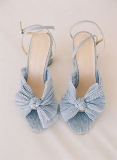 a pair of blue shoes with bows on them