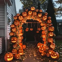 an archway made out of pumpkins with carved faces