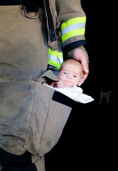 a firefighter holding a baby in his pocket