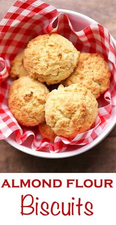 three biscuits in a bowl with the words almond flour biscuits on top and below it