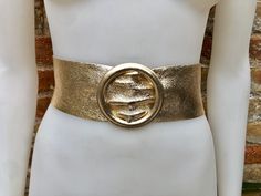 GOLD color belt in metallic effect GENUINE leather. Large round metallic buckle in GOLD The belt is 110 cm - 43 in long and 6,5  cm, 2 1/2 in wide Our genuine leather and soft suede obi belts  in different colors: https://www.etsy.com/es/shop/goodtimesbarcelona?section_id=10691564 Please contact us with any questions. Thank you vor visiting our shop Gold Waist Belt, Night Costume, Misty Night, Golden Belt, Leather Waist Belt, Gold Costume, Belt Gold, Gold Belt, Gold Belts