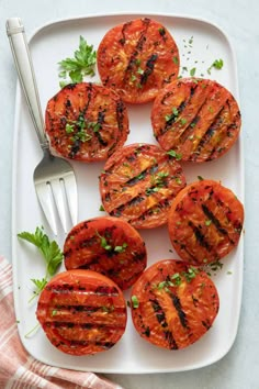 grilled tomatoes on a plate with a fork