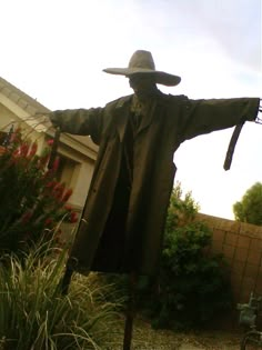 a statue of a man wearing a hat and trench coat