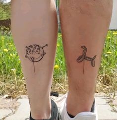 two people with tattoos on their legs standing next to each other in front of grass and flowers