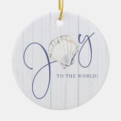 a white ornament with the word joy to the world written on it and a seashell