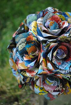 a flower made out of magazines sitting in the grass