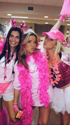 three women dressed in pink and white posing for the camera