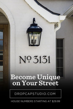 a white building with a black lamp on the side and text that reads no 511 become unique on your street