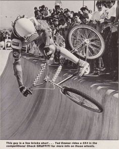 a man riding a bike up the side of a ramp in front of a crowd