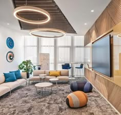 a living room filled with furniture and a flat screen tv mounted to the wall above it