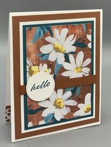 a handmade card with white flowers on brown and blue background, which says hello