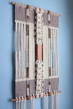 a wall hanging made out of yarn and wood sticks