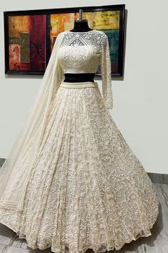 a white wedding gown on display in front of a painting