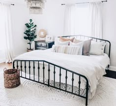 a bedroom with a white bed and chandelier hanging from it's ceiling