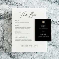 the bar menu on top of a marble counter with a black and white tag that says cheers to love