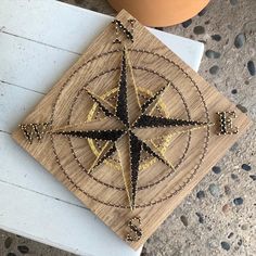 a wooden plaque with a compass on it