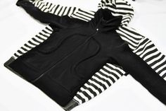 a black and white striped jacket laying on top of a bed