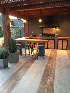 an outdoor kitchen and dining area with potted plants