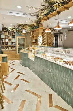 the interior of a bakery with green tile and gold accents