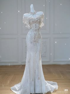 a white wedding dress on display in front of a wall with stars and sparkles